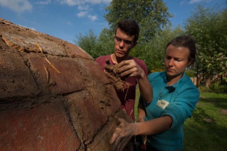 Zwei junge Menschen bauen einen Lehmbackofen in Wangelin zur Berufsorientierung im ökologischen Bauen