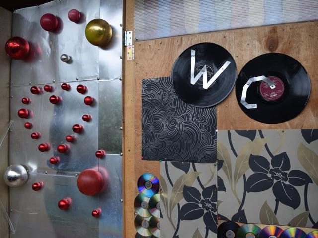 Die fertigen Türen des Badehäuschens Die fertigen Türen des Badehäuschens sind aus Recyclingmaterialien, wie Druckerblechen, Weihnachtskugeln und Schallplatten gestaltet. Auf der Tür zum WC rechts sind aus Blechstreifen die Buchstaben W und C auf je eine Schallplatte aufgebracht.