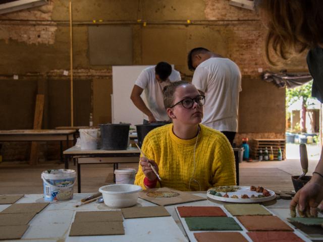Üben auf Musterplatten. | Foto: Hendrik Silbermann (ARTWORKs) Eine Teilnehmerin malt mit Lehmfarben auf Musterplatten. | Foto: Hendrik Silbermann (ARTWORKs)
