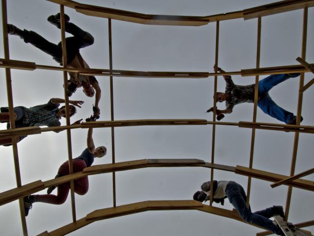 Die Teilnehmenden auf der Holzkonstruktion der Strohbrücke. | Foto: Hendrik Silbermann (ARTWORKs) Die Teilnehmenden klettern auf die Holzkonstruktion der Strohbrücke.