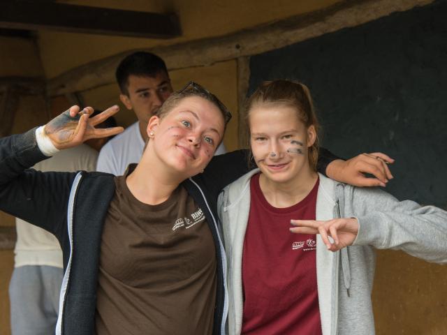 Fröhliche Gesichter. | Foto: Hendrik Silbermann (ARTWORKs) Fröhliche Gesichter beim Gestalten der Bushaltestelle. Zwei Mädchen lächeln und haben Farbe im Gesicht. | Foto: Hendrik Silbermann (ARTWORKs)