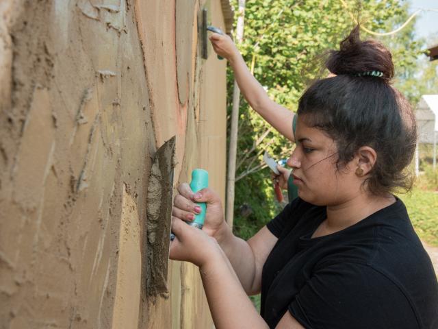 Gestaltung der Wand im Eingangsbereich der Bildungsstätte für Lehmbau. | Foto: Hendrik Silbermann (ARTWORKs) Ein Mädchen hilft bei der Gestaltung der Wand im Eingangsbereich der Bildungsstätte für Lehmbau. | Foto: Hendrik Silbermann (ARTWORKs)