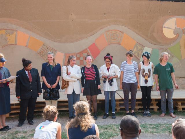 Die Teilnehmenden bei der Abschlusspräsentation vor ihrer "Welle". | Foto: Hendrik Silbermann (ARTWORKs) Die Teilnehmenden stehen bei der Abschlusspräsentation vor ihrer "Welle", einem farbigen Motiv an der Wand im Hintergrund. | Foto: Hendrik Silbermann (ARTWORKs)