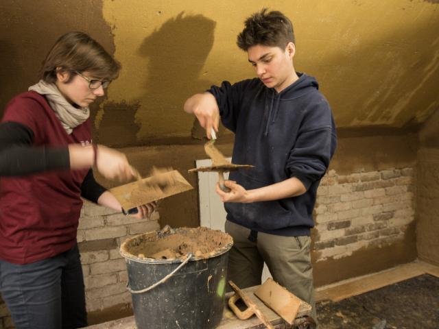 Lehmarbeiten | Foto: Hendrik Silbermann (ARTWORKs) Zwei Teilnehmende entnehmen Lehm aus einem Eimer. | Foto: Hendrik Silbermann (ARTWORKs)