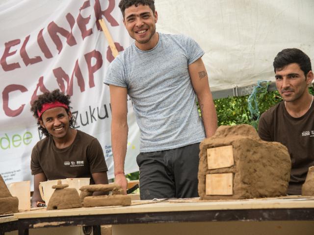 Alle sind gut gelaunt. | Foto: Hendrik Silbermann (ARTWORKs) Teilnehmende lachen neben Modellen aus Lehm. | Foto: Hendrik Silbermann (ARTWORKs)