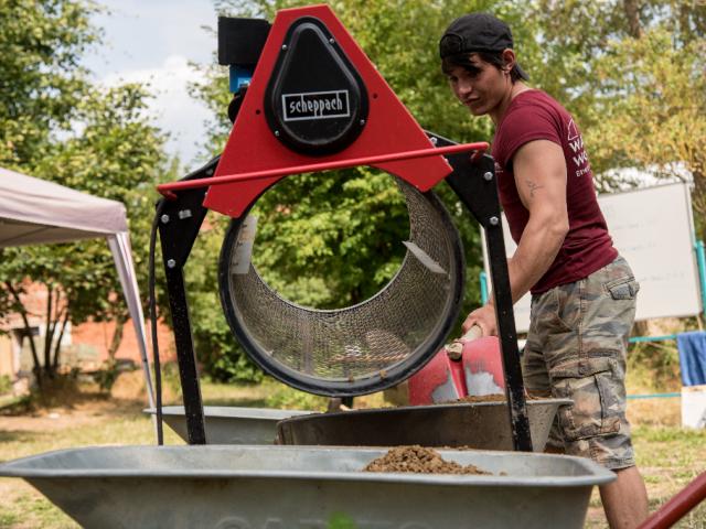 Mit einem Rollsieb werden Steine und Kies aus dem Material entfernt. | Foto: Hendrik Silbermann (ARTWORKs) Mit einem Rollsieb werden Steine und Kies aus dem Material zum Arbeiten von einem Jungen entfernt. | Foto: Hendrik Silbermann (ARTWORKs)