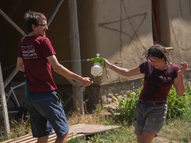 Wasserschlacht. | Foto: Hendrik Silbermann (ARTWORKs) Zwei Teilnehmende machen eine Wasserschlacht und besprühen sich mit Sprühflaschen von der Baustelle. | Foto: Hendrik Silbermann (ARTWORKs)
