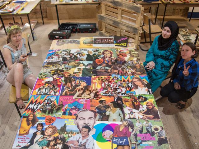 Gestaltung der Toilettenwand mit Schallplatten-Covern. | Foto: Hendrik Silbermann (ARTWORKs) Gestaltung der Toilettenwand mit Schallplatten-Covern durch Upcycling-Teilnehmende. | Foto: Hendrik Silbermann (ARTWORKs)