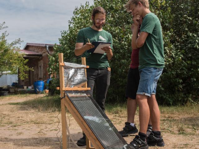 Teilnehmende erforschen die Kraft der Sonne mittels verschiedener Experimente. | Foto: Hendrik Silbermann (ARTWORks) Teilnehmende erforschen die Kraft der Sonne mittels verschiedener Experimente mit Glas und einem Heizungskollektor. | Foto: Hendrik Silbermann (ARTWORks)