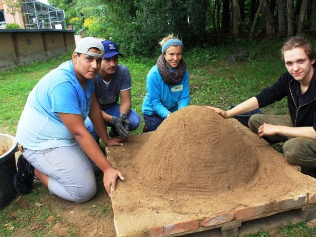 Workcamp-Teilnehmende beim Lehmofenbau. | Foto: FAL e.V. Workcamp-Teilnehmende beim Lehmofenbau
