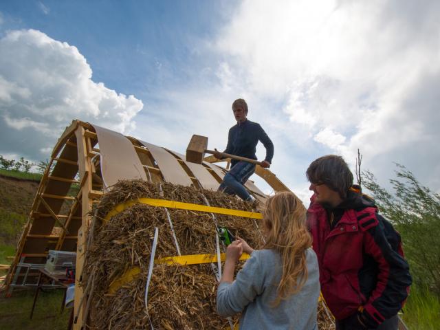 Bau der Strohbrücke | Foto: Hendrik Silbermann (ARTWORKs) Ein Teilnehmer befestigt die Strohballen auf der Brücke