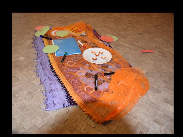 Zukunftswerkstatt Auf dem Boden liegen bunte orientalische Tücher, kleine Kerzen brennen, farbige Papiere und Stifte liegen bereit.