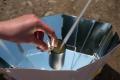 Teilnehmerinnen erhitzen Wasser durch die Sonneneinstrahlung im Parabolspiegel